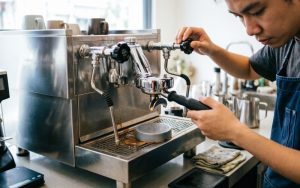 a-barista-backflushing-a-coffee-machine-with-a-cle
