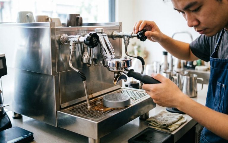 a-barista-backflushing-a-coffee-machine-with-a-cle